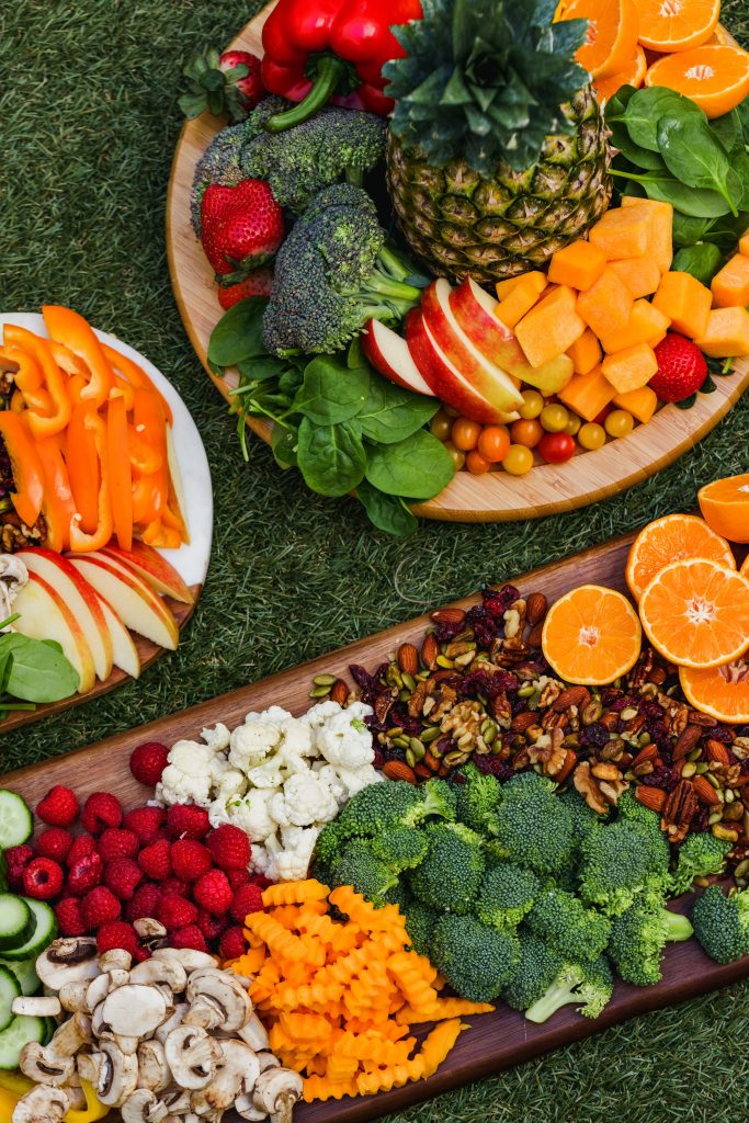 Neatly presented platters of assorted fruits, vegetables, and nuts, essential for maintaining healthy cholesterol levels.