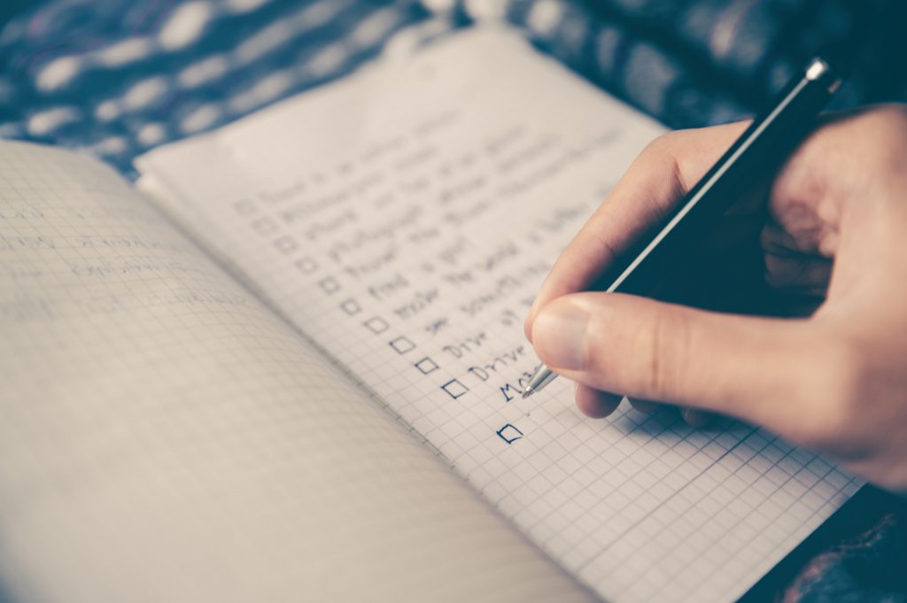 A woman writing in a food journal, highlighting its importance in her health journey."