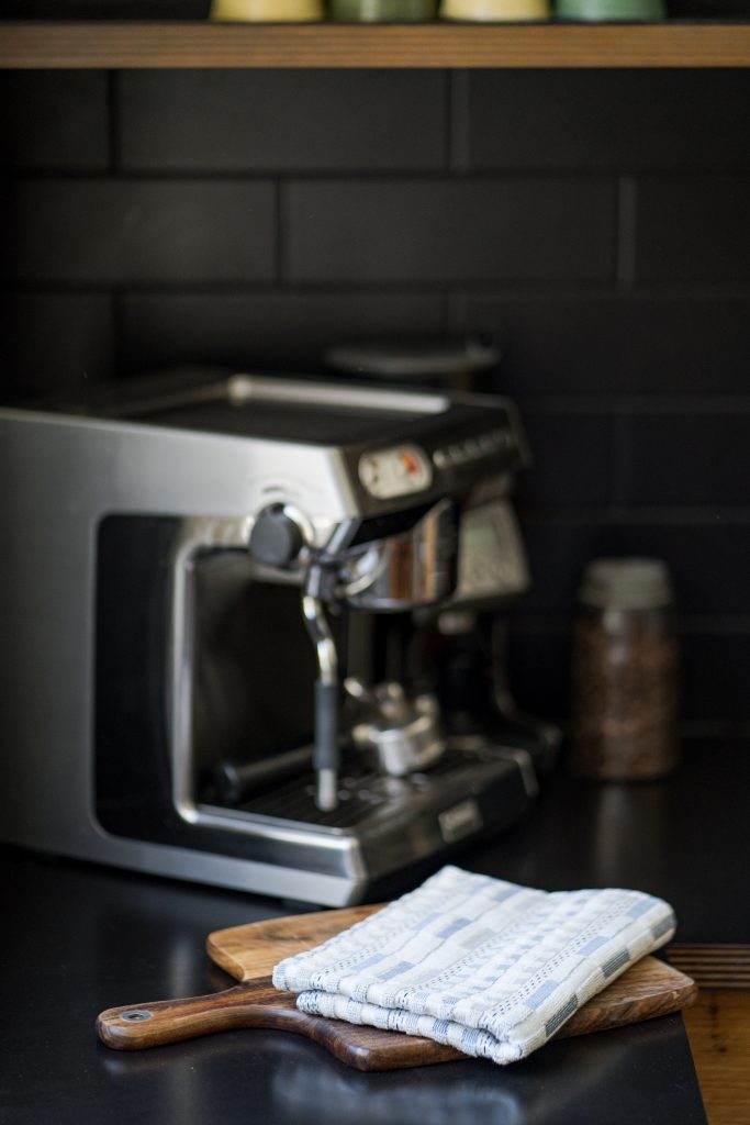 An aesthetic shot of a neatly folded kitchen towel on a kitchen counter.