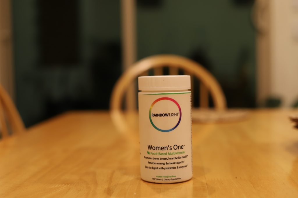 A jar of food-based multivitamin pills placed on a table.