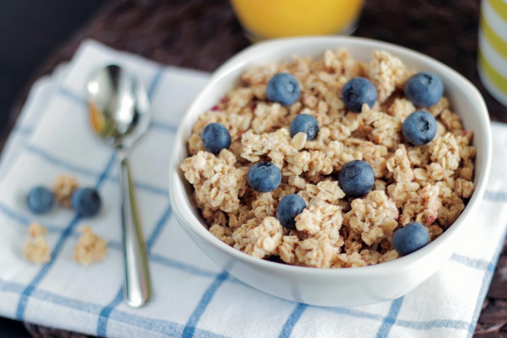 Oatmeal rich in beta-glucan, B vitamins, iron, and manganese, neatly presented in a white bowl topped with berries.