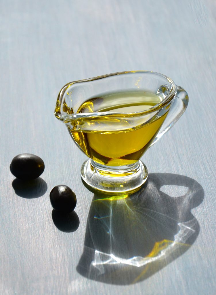 An aesthetic shot of olive oil filled in a beautiful glass jar.
