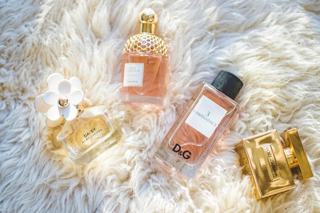 Perfume bottles in exotic shapes arranged elegantly on a luxurious fur cloth, a possible cause for allergies.