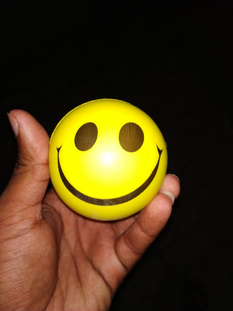 A close-up shot of a person holding a stress ball, an easy, portable, and non-violent way to relieve tension.