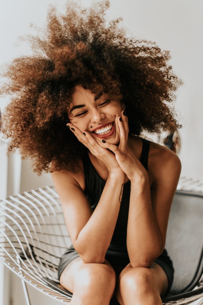 A candid picture of a cheerful young girl, smiling and happy after successfully losing weight.