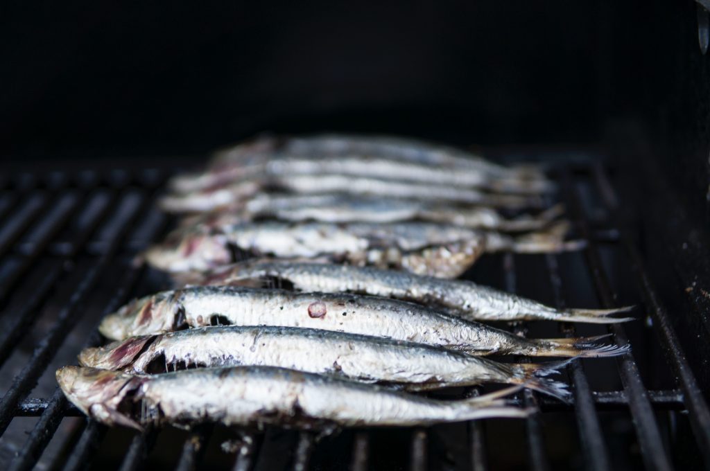 Fish arranged on a barbecue grill, providing calcium, an essential mineral for strong bones and teeth.