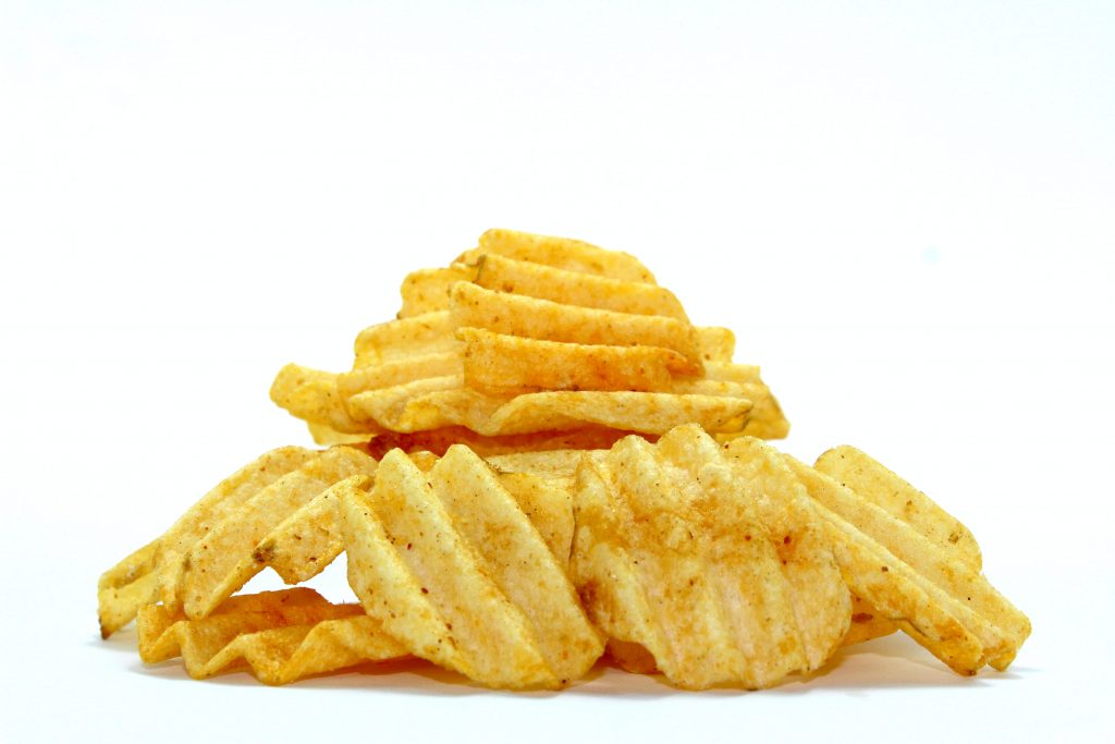Crispy chips on the ground, representing the dangers of excess phosphorus in processed foods for kidney and bone health.
