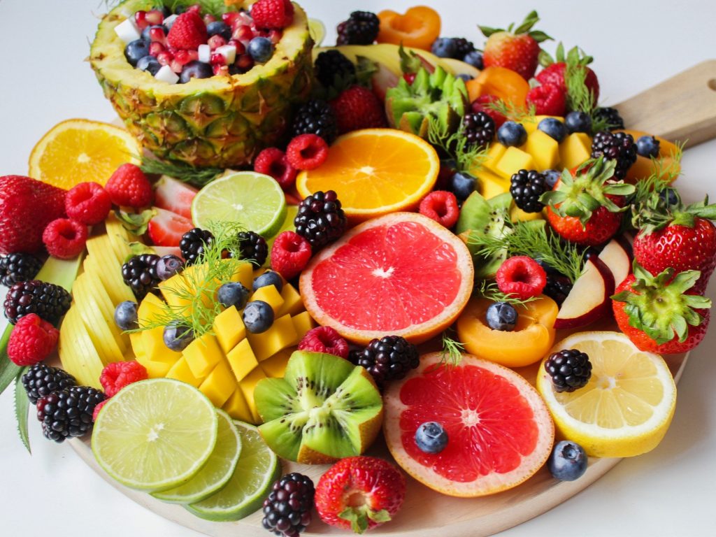 A colorful fruit platter with mango, pineapple, oranges, and lime, supporting a balanced diet and healthy weight.