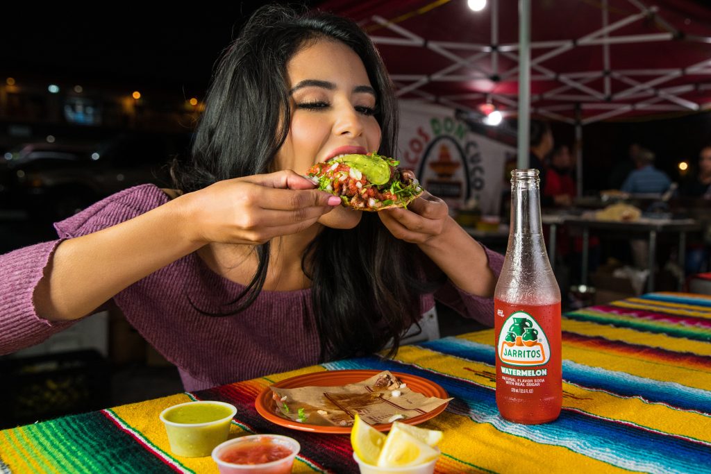 Woman consuming processed food quickly, emphasizing its link to difficulty in losing belly fat.