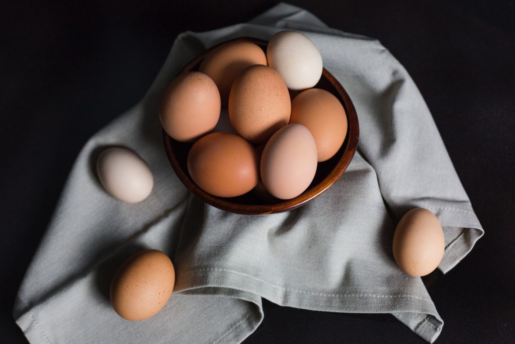 A bowl of brown eggs on a gray napkin, rich in nutrients that support protein and fat metabolism for healthy growth.
