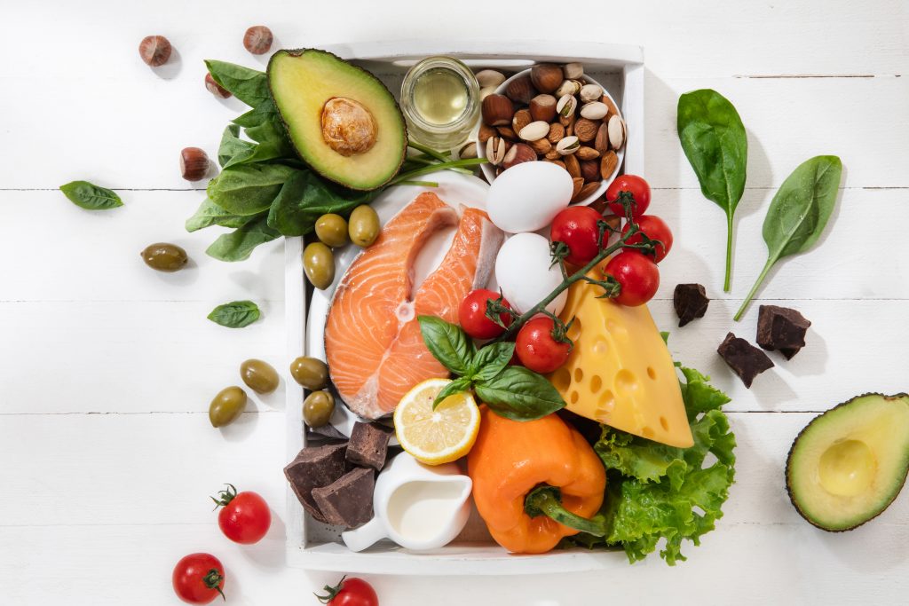 Healthy foods like salmon, avocado, eggs, olives, nuts, and vegetables, providing protein to keep you full and reduce calorie intake.
