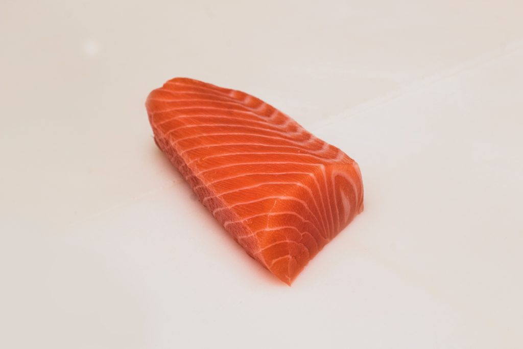 A single piece of sea fish on a white background, rich in Omega-3 to boost thyroid function.
