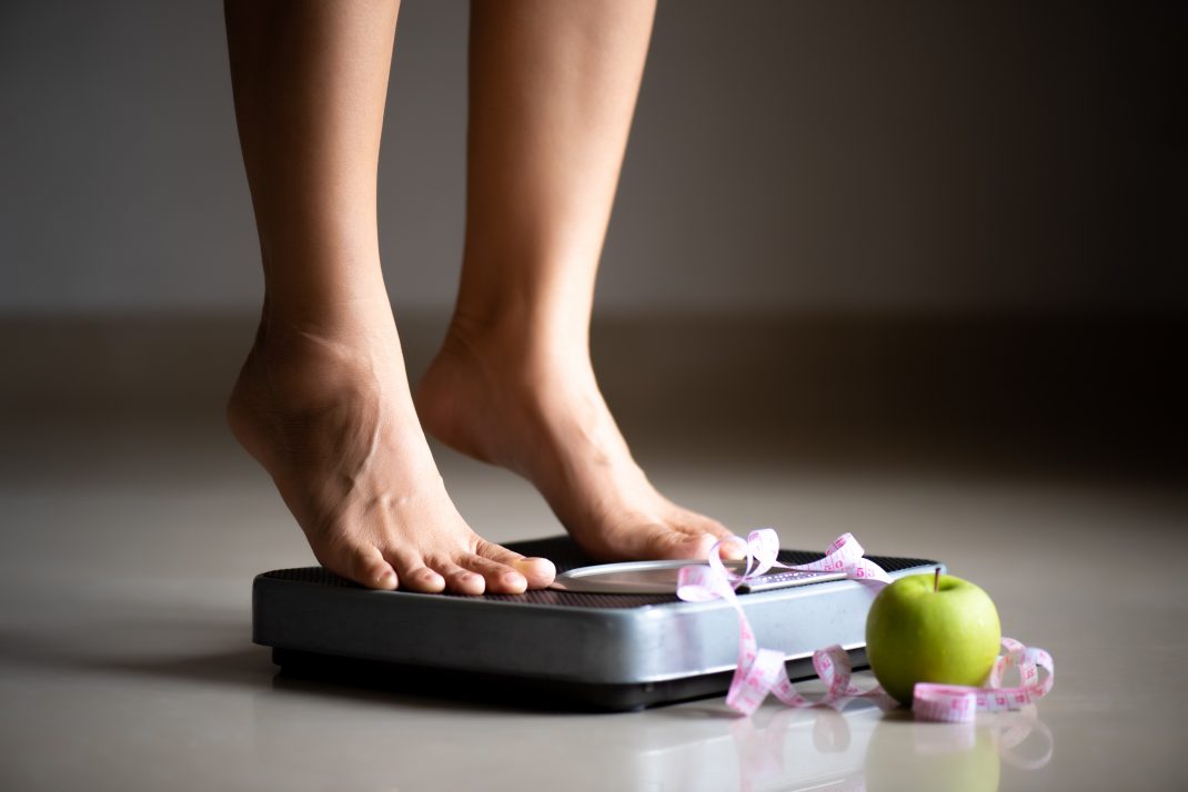 A woman writing in a food journal, highlighting its importance in her health journey."