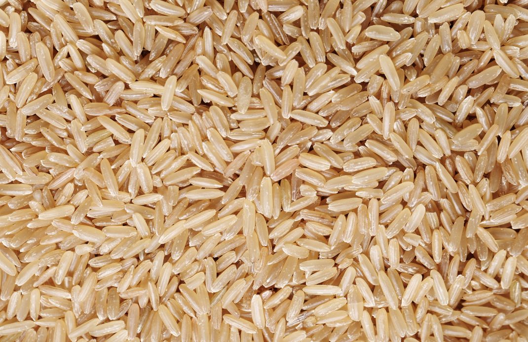 A close-up view of uncooked brown rice long grains, known for being a natural and rich source of magnesium.