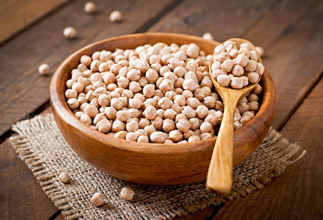 A bowl of chickpeas with a wooden spoon, highlighting chickpeas as a magnesium-rich food for a healthy diet.