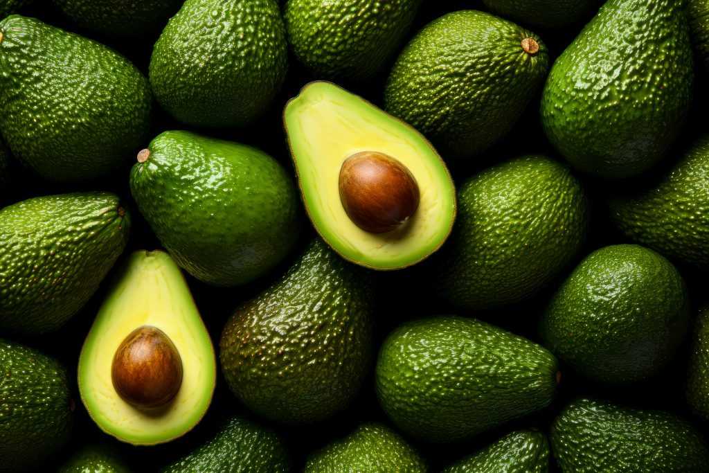 A pile of avocados, cut in half to reveal the pulp and seed, packed with healthy fats and fiber to boost heart health.